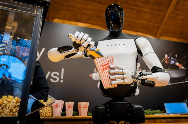 看看新闻报道，特斯拉人形机器人Optimus“擎天柱”近日展示了其在服务场景中的新技能——售卖爆米花。  在一段演示中，它完整执行了取盒、定量装填、精准封袋等一系列动作，展现出连贯流畅的工作能力。  